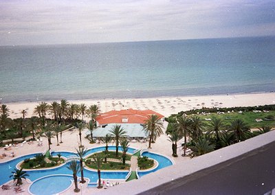 Mid-20th century seaside resort with tiered pools, palm-dotted gardens, and oceanfront beach. Architectural style suggests 19...