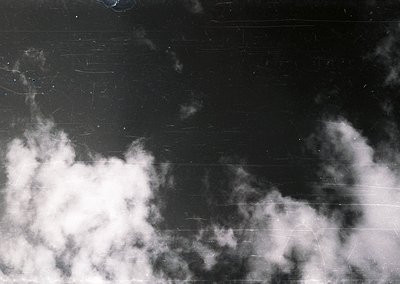 High-contrast black-and-white sky with dense, textured clouds against a dark, slightly scratched surface. Dramatic lighting e...