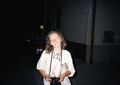 Vintage candid of a person in a 1970s-style lanyard with a lanyard badge and a small trophy, likely from an event or competit...