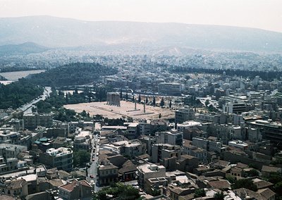Aerial view of the **Ancient Agora of Athens**, showcasing its central ruins surrounded by dense urban sprawl. Mid-20th centu...