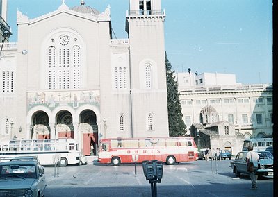 Neoclassical church façade with arched entryways, decorative columns, and circular windows, likely from the mid-20th century....