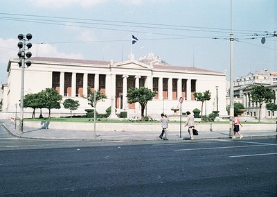 Neoclassical building with prominent columns and pediment, likely a government or cultural institution, set against a clear s...