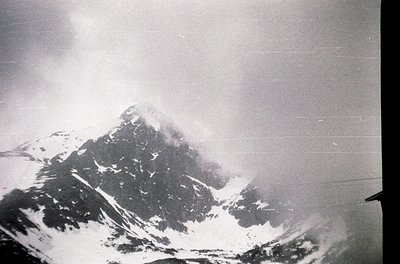 Classic aerial view of a snow-capped alpine peak shrouded in mist, likely the Matterhorn. Black-and-white composition highlig...