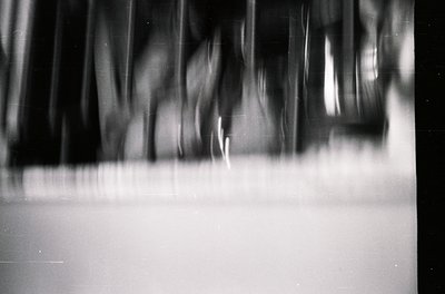 Blurred motion photography capturing dynamic movement in monochrome. Vertical streaks suggest rapid, repetitive action—likely...