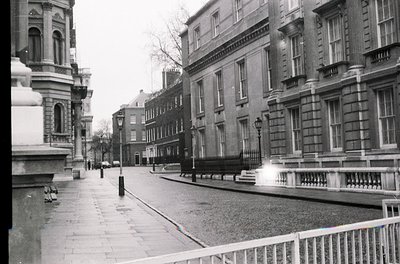 Neatly preserved mid-20th century urban street in classic European architecture. Symmetrical row of brick buildings with orna...