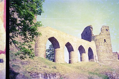 Vintage photograph of a medieval stone ruin featuring three arched doorways and a tower remnant, likely Byzantine or early Ch...