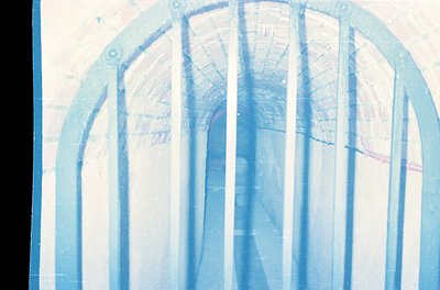 Vintage architectural blueprint overlaying a curved structural design, likely a bridge or arch. The translucent tracing sugge...