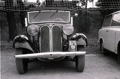 Classic 1930s BMW 303 roadster with vertical chrome grille and dual round headlamps, license plate "875" visible. Black-and-w...