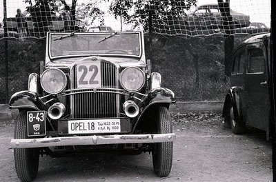 1933 Opel 1.8L Typ 1033 race car (-43) in vintage rally setup. Rounded headlights, wire-spoke wheels, and racing number 22 pr...