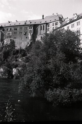 Historic stone fortress perched on rocky cliffs beside a river, mid-20th century. Symmetrical towers and battlements suggest ...