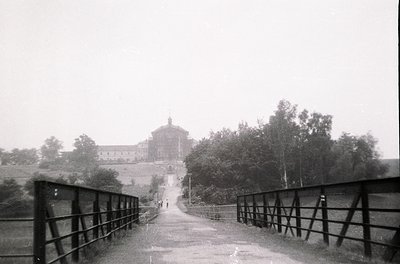 Vintage black-and-white photograph of a grand, cylindrical building with a dome, likely a monastery or historic estate, frame...