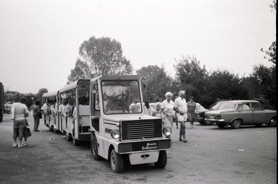 Vintage **miniature railway train** with open-air carriages, likely from the **1960s-1970s**, parked in an outdoor setting. P...