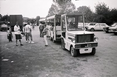 Vintage **Belfancer** shuttle bus parked in a mid-20th-century outdoor setting, likely a transport hub or industrial area. Pe...