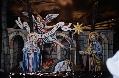 Religious nativity mural depicting Christ’s birth: angel announces *"God Excelsis Deo"* (Luke 2:11), Mary cradles infant Jesu...