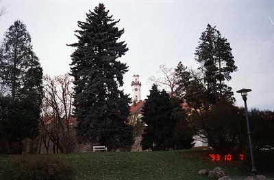 Vintage photo of a park-like setting with a historic tower in the background, likely European. The date stamp "93 10 7" sugge...