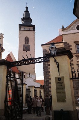Historic wrought-iron gate entrance to **Zámek Telč**, a 16th-century Renaissance castle in Czech Republic. Prominent tower w...