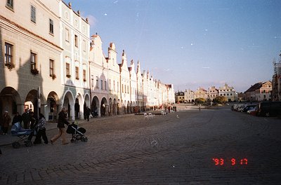 Historic European plaza with Renaissance-style arcaded buildings, likely 1993. Cobblestone street lined with whitewashed faca...