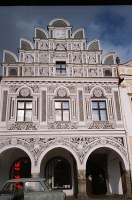 Baroque-style building façade featuring intricate stucco reliefs, arched windows, and decorative pediments. Symmetrical desig...