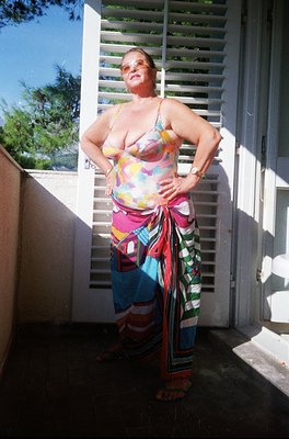 Vintage beachwear featuring bold geometric patterns in a tie-dye-inspired style, worn by an individual posing outdoors near a...
