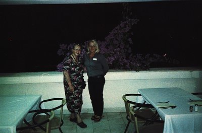 Two individuals pose outdoors at night under artificial lighting, likely at a resort or event venue. The woman on the left we...