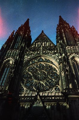 Gothic cathedral façade featuring intricate stonework, spires, and a prominent rose window with tracery. Likely European, 13t...