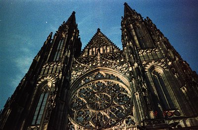 Gothic cathedral façade featuring intricate stonework, twin spires, and a grand rose window with tracery. Likely European, 13...