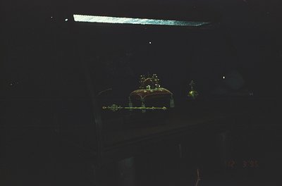 Low-light shot of a **retro analog audio cassette** in a dark case, illuminated by faint green/yellow light. Reflections and ...