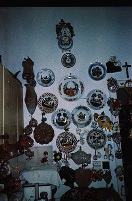Vintage ceramic collection displayed on a light blue wall, featuring plates, vases, and decorative tiles with floral, geometr...