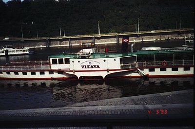 Vintage riverboat "Vltava" docked at Prague’s historic waterfront, featuring classic 1960s-70s passenger ferry design with re...