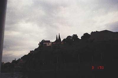 Silhouetted hilltop church with twin spires against dusk sky, framed by low-angle shot. Date stamp "3.1993" suggests early 19...