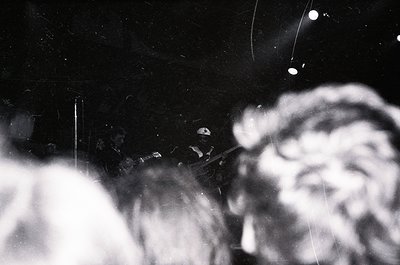 Vintage black-and-white photo of a close-up nighttime scene featuring a blurred, illuminated face and a cigarette held betwee...