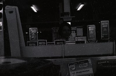 Vintage black-and-white photo of a dimly lit industrial or warehouse setting, featuring stacked "Rohtan" branded leather prod...