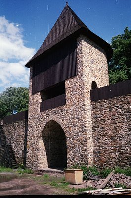 Historic stone watchtower with timber-framed upper section, featuring a steep gable roof and arched entrance. Constructed fro...