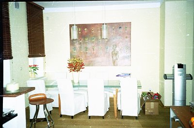 Mid-century modern café interior with minimalist design. White vinyl chairs, a small bar counter, and a vintage wall mural de...