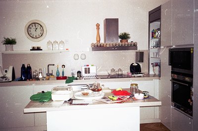 Vintage kitchen with retro white laminate countertops, featuring a built-in microwave, electric kettle, and retro clock. Deco...