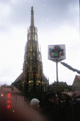 Gothic spire of the Frauenkirche in Dresden, Germany, adorned with festive garlands, likely during the 1960s or 1970s. The si...