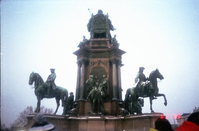 Neoclassical equestrian monument featuring three mounted figures flanking a central seated group atop an ornate pedestal. Int...
