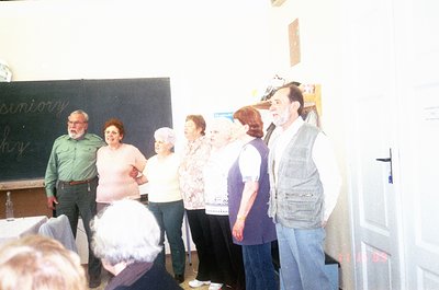 Vintage classroom scene featuring a group of elderly individuals participating in a senior choir or workshop. Blackboard with...