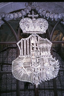 Artistic skeletal crown and coat-of-arms crafted from human bones, mounted on a stone arch. Likely part of a **Cathedral of t...