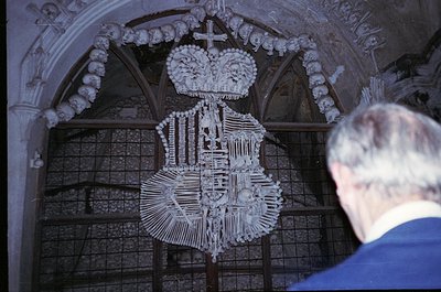 Bone altar piece featuring a crucifix and coat of arms, framed by Gothic-style arches. Likely a 16th–18th century European os...