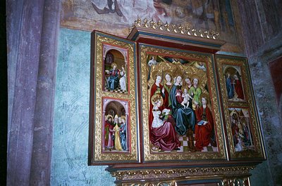 Vibrant 19th-century religious iconostasis featuring Byzantine-style frescoes. Central panel depicts Christ enthroned with ap...