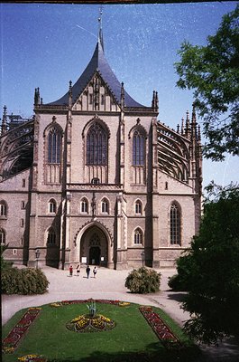 Gothic-style cathedral façade with pointed arches, tall stained-glass windows, and intricate stone detailing. Symmetrical cou...