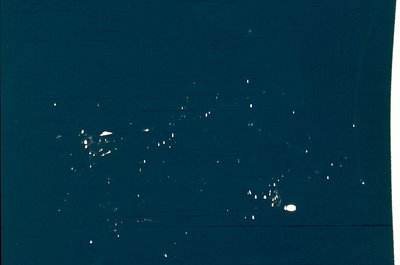 Vintage black-and-white aerial photo of scattered ice crystals on a dark surface, likely a window or glass pane. Composition ...