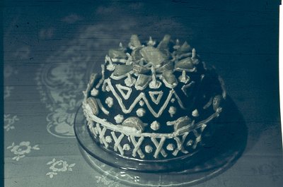 Vintage decorative cake topper featuring geometric and floral motifs, likely from the 1950s–1970s. Intricate silver filigree ...
