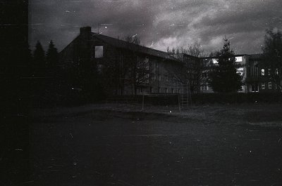 Mid-century concrete apartment block with minimalist Brutalist design, featuring exposed concrete walls and a flat roof. Bare...