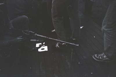 Black-and-white close-up of a vintage 8-track tape player on a reflective surface, with a cassette labeled "50" placed on the...