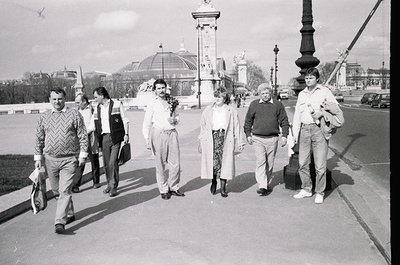 Group of six individuals crossing a bridge in Moscow, 1970s. Men in patterned sweaters, trousers, and leather jackets; women ...