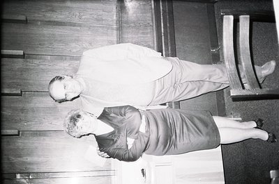 Two individuals in mid-air performing a synchronized stunt on wooden stairs, likely from a 1960s-1970s circus or acrobatics p...