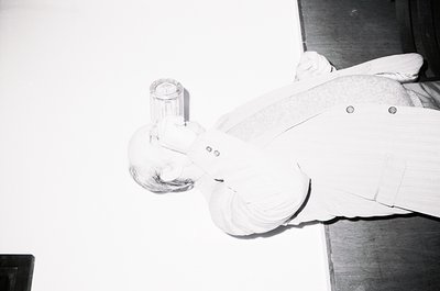 Close-up of a vintage glass ashtray shaped like a curled cigarette, featuring a hollowed-out design for ash collection. The s...