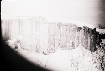 Vintage black-and-white shot of a stone wall with vertical, evenly spaced bricks—likely a historic or agricultural boundary. ...